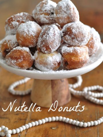 Nutella Filled Donuts: This easy donut dough is made in the brad machine, mini sized, covered in powdered sugar and filled with nutella.