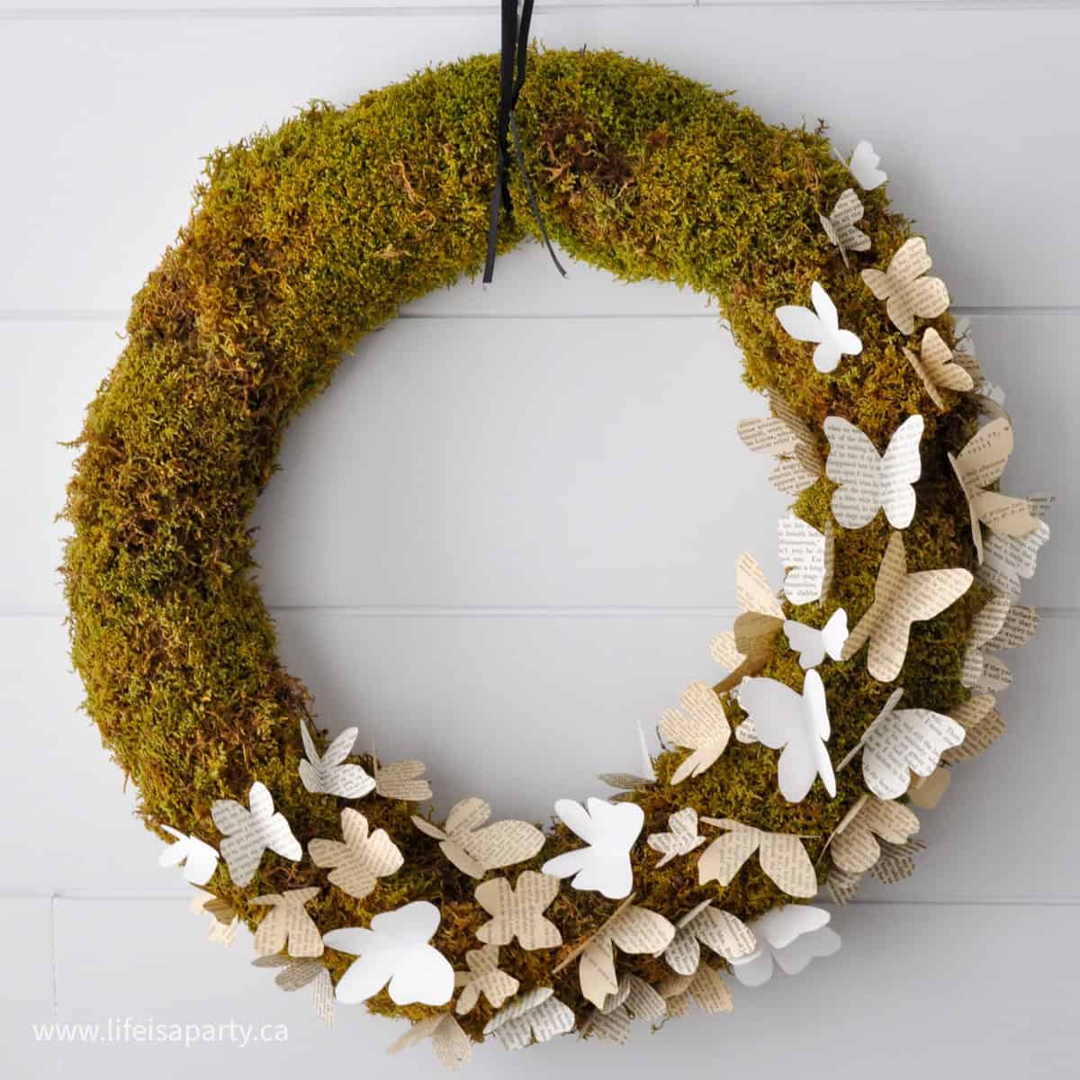 DIY butterfly wreath with book page butterflies and moss wreath.