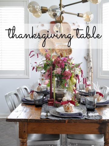 Thanksgiving Tablescape Ideas: grey, pink, and burgandy come together for a rustic Thanksgiving tablescape with candles, flowers, and favours.