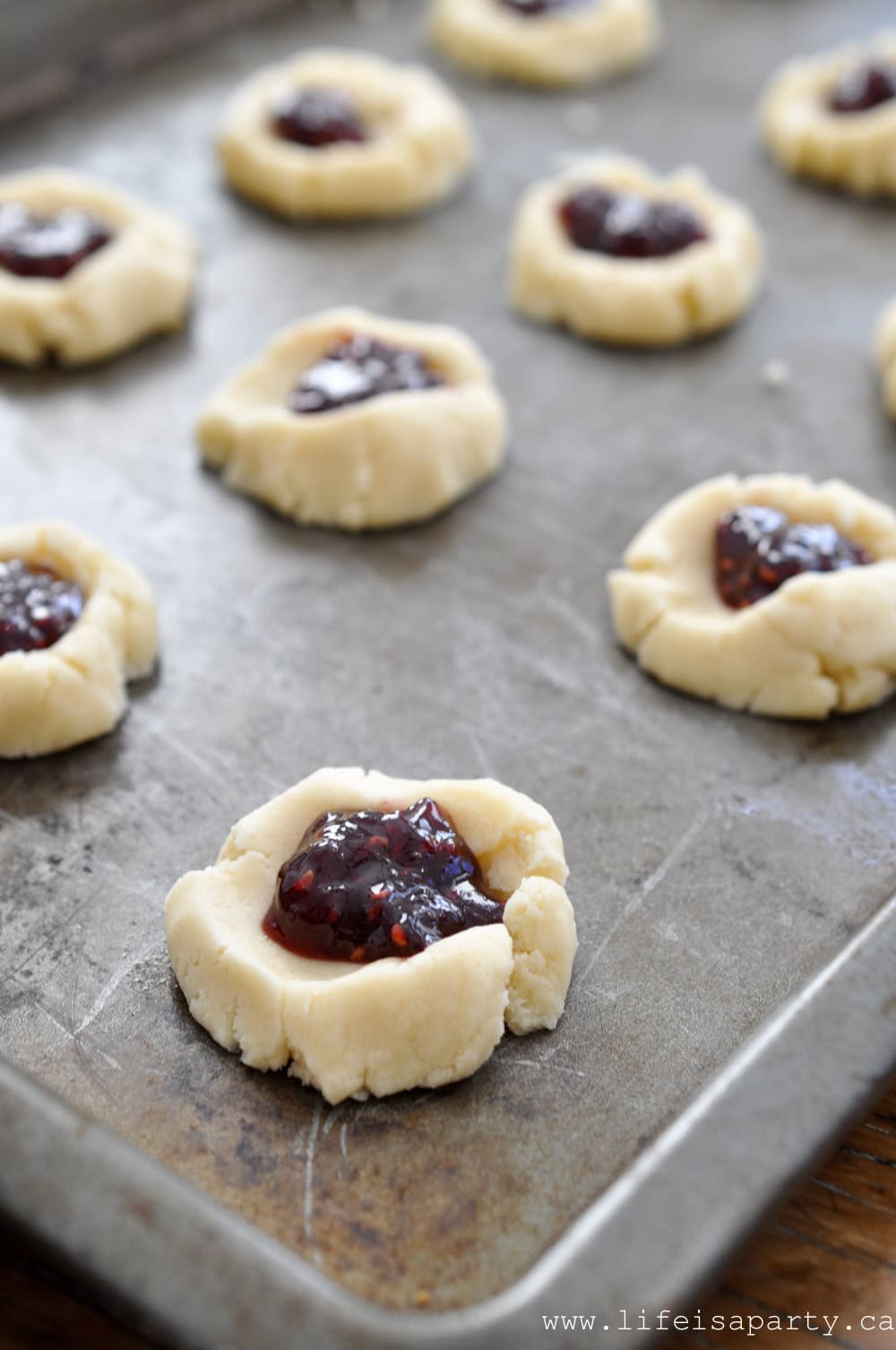 How to make almond thumbprint cookies with raspberry jam.